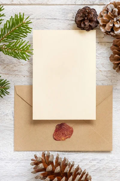 冬季圣诞构图用卡片盖住密封的信封 圣诞和新年贺卡模板与冷杉树枝和松果白色木制背景顶部视图 假日恶作剧 — 图库照片