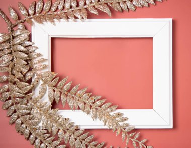 Beyaz çerçeveli ve pembe arka plan manzaralı Noel altın yapraklarıyla süslenmiş.