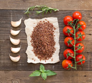 Organik kırmızı pirinç, domates, sarımsak ve otlar üzerinde ahşap adam