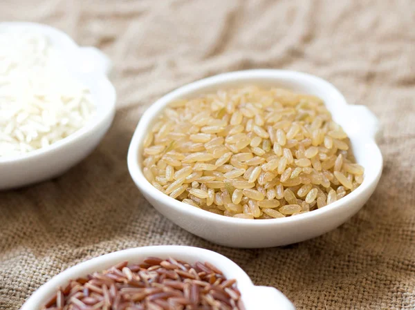 Odmiany ryżu w miski na drewnianym stole — Zdjęcie stockowe