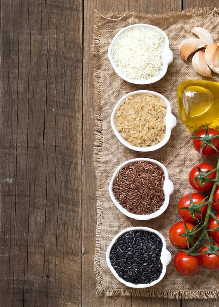 Variedade de arroz em tigelas em mesa de madeira — Fotografia de Stock