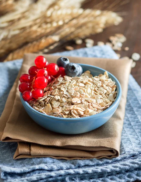 Avena arrotolata in una ciotola con bacche — Foto Stock