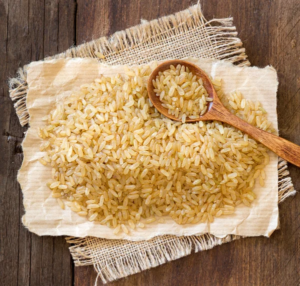 Unpolished rice with a spoon — Stock Photo, Image