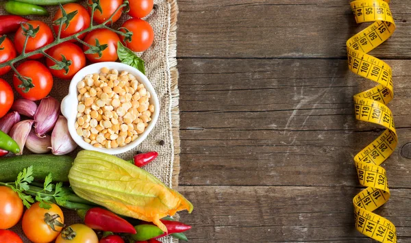 Ervilhas amarelas orgânicas cruas em tigela e legumes — Fotografia de Stock