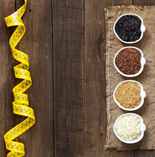 Variedad de arroz en cuencos sobre mesa de madera —  Fotos de Stock