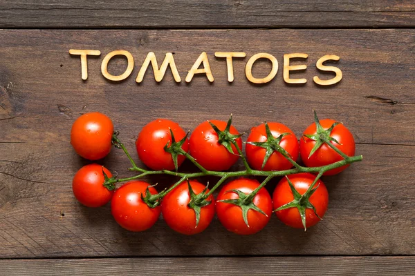 Tomates cereja e palavra Tomates — Fotografia de Stock