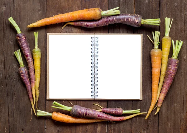 Cenouras de arco-íris orgânico fresco com livro de receitas — Fotografia de Stock