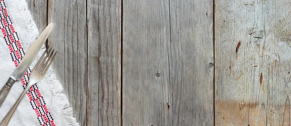 Tło widelec i nóż w serwetkę na Stare drewno — Zdjęcie stockowe