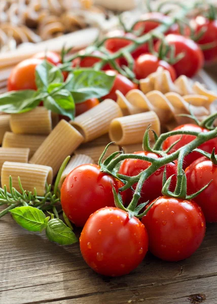 Pasta, garlic, herbs and tomatoes — Stock Photo, Image