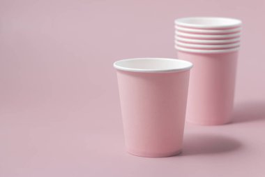 Tek kullanımlık pembe kağıt bardaklar yakın çekim izole edilmiş, reklam alanı olan bir model. Boş karton kahve fincanları. Kapağı olmayan çevre dostu tek kullanımlık konteynırlar, plastikten ayrıştırılabilir materyal yok.