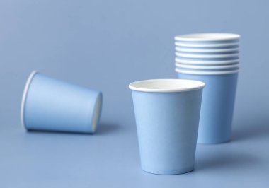 Tek kullanımlık açık mavi bardaklar yakın çekim izole edilmiş, reklam alanı olan bir model. Boş karton kahve fincanları. Kapağı olmayan çevre dostu tek kullanımlık konteynırlar, plastikten ayrıştırılabilir materyal yok.