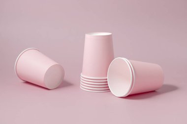 Tek kullanımlık pembe kağıt bardaklar yakın çekim izole edilmiş, reklam alanı olan bir model. Boş karton kahve fincanları. Kapağı olmayan çevre dostu tek kullanımlık konteynırlar, plastikten ayrıştırılabilir materyal yok.