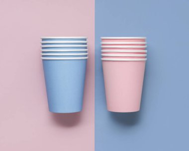 Tek kullanımlık açık mavi ve pembe kahve fincanları üst görüntüyü izole etti, reklam alanı ile modellendi. Boş karton kahve fincanları. Çevre dostu tek kullanımlık kapaksız, plastik bardaksız kalkış konteynırları