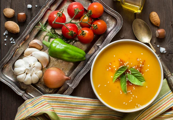 Verse pompoen soep en groenten op een houten tafel — Stockfoto