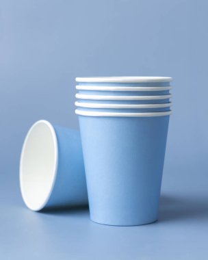Tek kullanımlık açık mavi bardaklar yakın çekim izole edilmiş, reklam alanı olan bir model. Boş karton kahve fincanları. Kapağı olmayan çevre dostu tek kullanımlık konteynırlar, plastikten ayrıştırılabilir materyal yok.