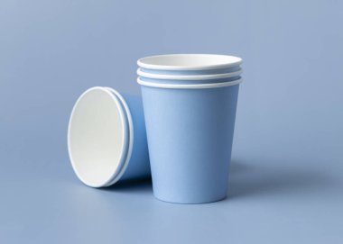 Tek kullanımlık açık mavi bardaklar yakın çekim izole edilmiş, reklam alanı olan bir model. Boş karton kahve fincanları. Kapağı olmayan çevre dostu tek kullanımlık konteynırlar, plastikten ayrıştırılabilir materyal yok.