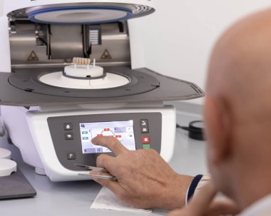 Ortodont erkekler diş implantı diş minesi pişirmek için diş seramik fırını programlarlar. Takma diş, taç ya da kaplama yapımında kullanılan profesyonel ekipman ve işlemler. Diş protezinde gelişmiş teknoloji.