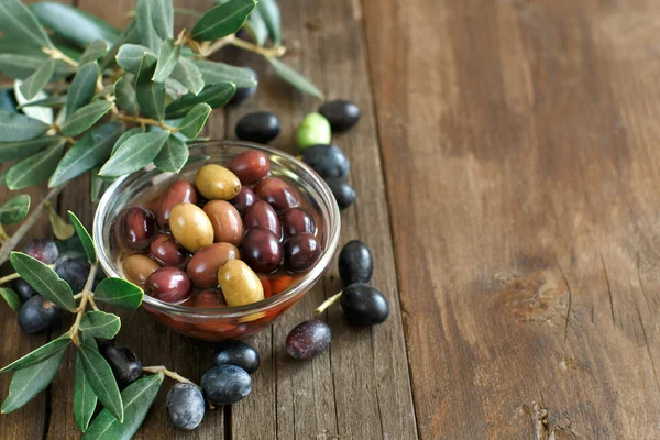 Fresh olives and olive branch on wood background — Stock Photo, Image