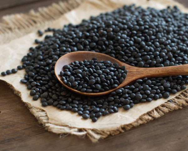 Black Lentils with a spoon — Stock Photo, Image