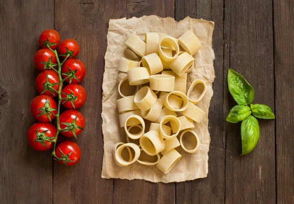 Pasta con tomates y albahaca sobre fondo de madera — Foto de Stock