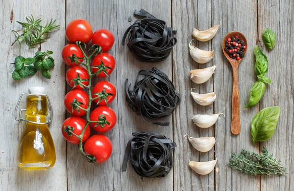 Száraz tészta Tagliatelle fekete cseresznye paradicsom, fokhagyma, és neki — Stock Fotó