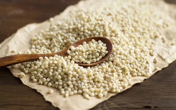 Grano de sorgo blanco con una cuchara —  Fotos de Stock