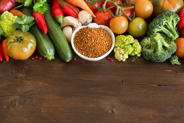 Uncookes mijo marrón en un tazón con verduras —  Fotos de Stock