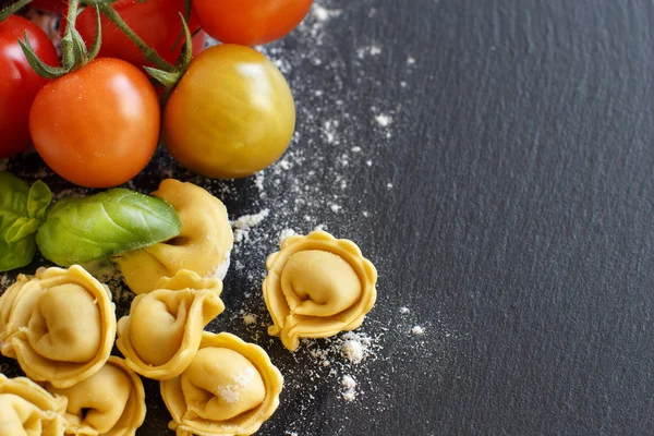 Homemade raw tortellini with fresh tomatoes and basil — Stock Photo, Image