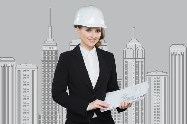 Smiling businesswoman in helmet studying the sketch of future business centre.