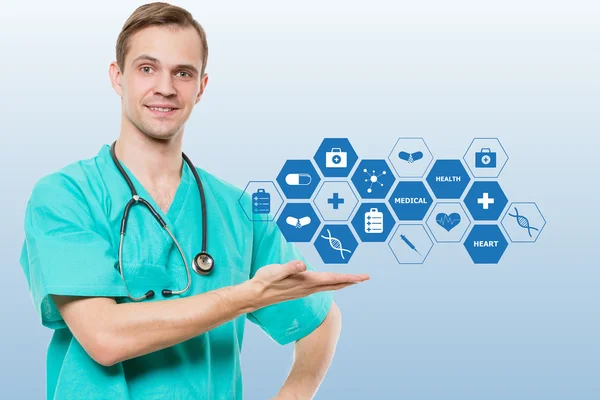 Healthcare, profession, symbols, people and medicine concept - smiling male doctor  in coat over blue background with medical icons — Stock Photo, Image