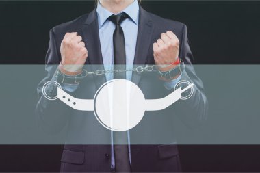 man in a business suit with chained hands. handcuffs for sex games. concept of erotic entertainment.