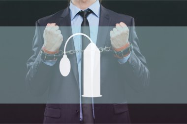 man in a business suit with chained hands. handcuffs for sex games. concept of erotic entertainment.