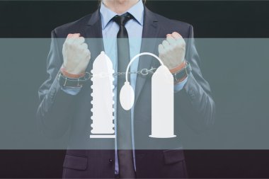 man in a business suit with chained hands. handcuffs for sex games. concept of erotic entertainment.