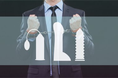 man in a business suit with chained hands. handcuffs for sex games. concept of erotic entertainment.