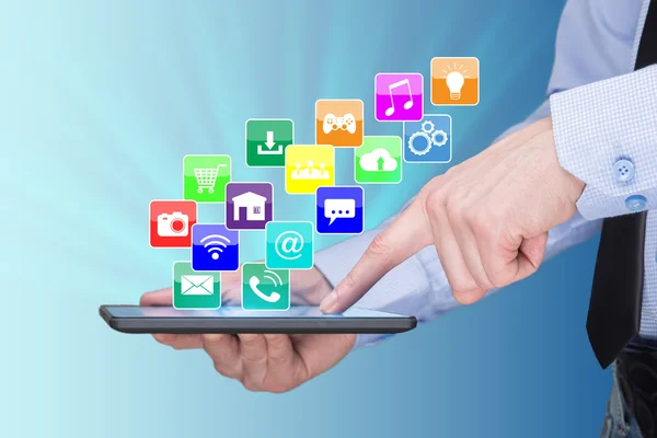 Geschäftsmann hält einen Tablet-PC mit Icons für mobile Anwendungen auf dem virtuellen Bildschirm. Internet und Geschäftskonzept. — Stockfoto