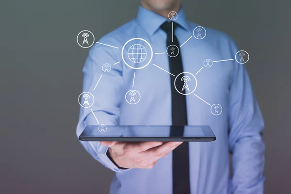 Hombre de negocios sosteniendo una tableta PC. Muestra torres de telecomunicaciones. concepto de comunicación — Foto de Stock