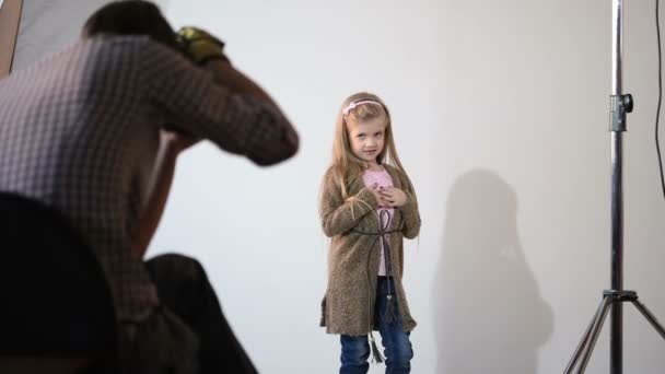 Photographer taking pictures of the child in the studio. — Stock Video