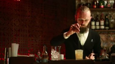 Sosyetik barda kokteyl hazırlayan yakışıklı barmen.