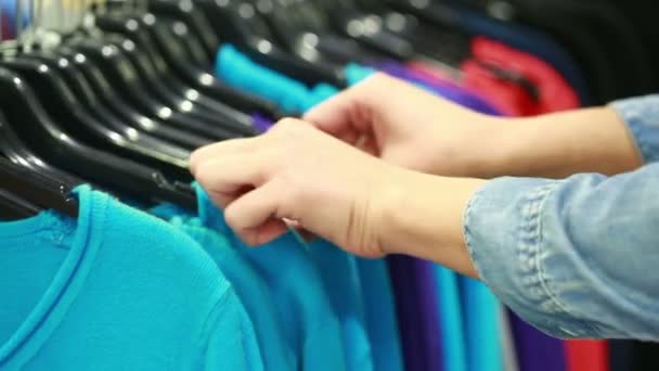 Kupující vybírá tričko v butiku — Stock video