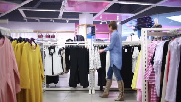 Ganska elegant kvinna shopping i kläder butik — Stockvideo