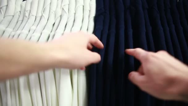 Мужчина покупатель ищет футболки в магазине моды — стоковое видео