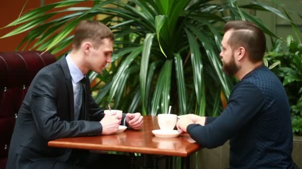 Dos hombres de negocios estrechando la mano en un café — Vídeo de stock