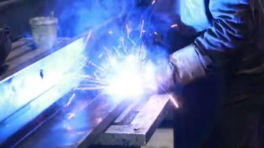 Koruyucu maskeli, kaynak yapan bir işçi.