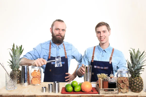 Two bartender with a shaker and bottle on white background. behind the bar — Stock Photo, Image