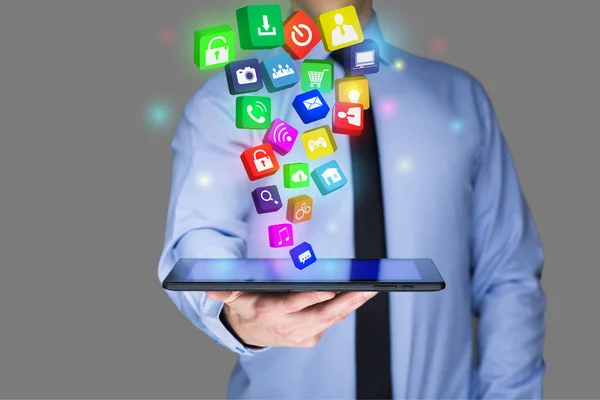 Affärsman innehar en TabletPC med mobila applikationer ikoner på virtuella skärmen. Internet och affärsidé. — Stockfoto