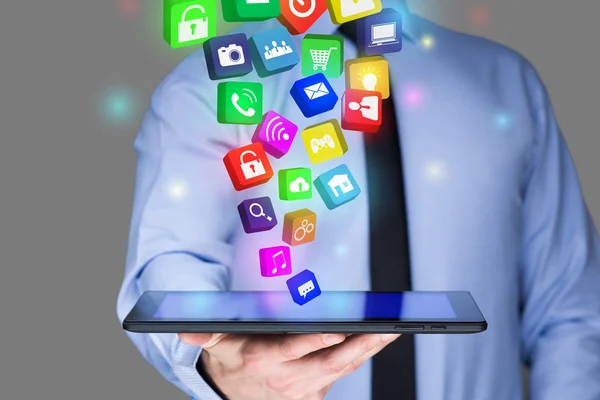 Empresario sosteniendo una PC tableta con iconos de aplicaciones móviles en la pantalla virtual. Concepto de Internet y negocios . — Foto de Stock