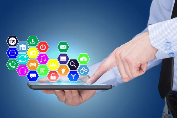 Empresario sosteniendo una PC tableta con iconos de aplicaciones móviles en la pantalla virtual. Concepto de Internet y negocios . — Foto de Stock