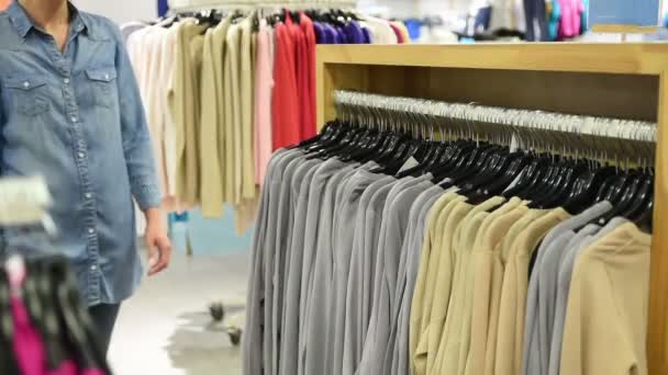 Belle femme faisant du shopping dans un magasin de vêtements — Video