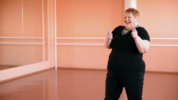 Menina gorda está envolvida em danças no salão. gordo alegre, ginástica e dança — Vídeo de Stock