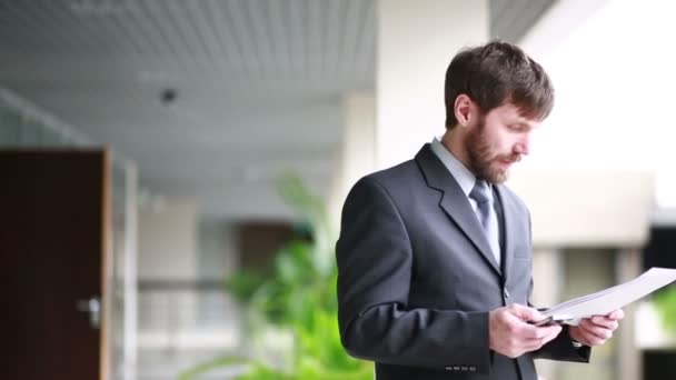 Reifer Geschäftsmann arbeitet am Arbeitsplatz mit Papieren und Handy — Stockvideo